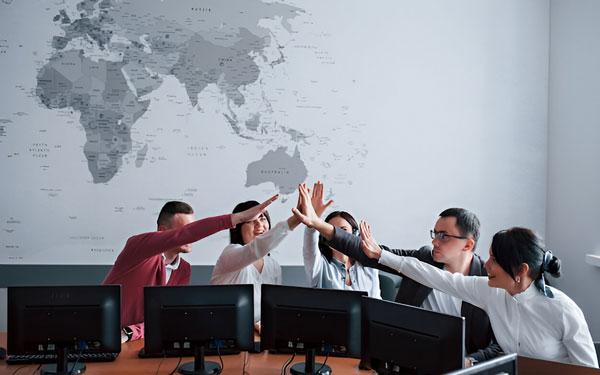 An operations team coordinating work beneath a world map